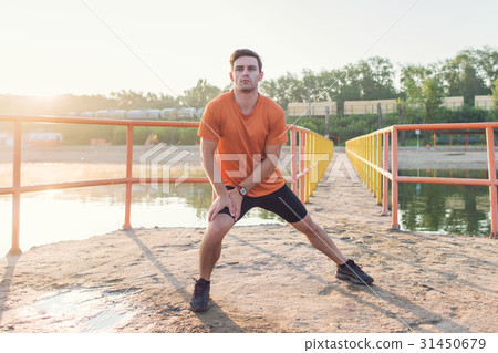 Fit man warming up doing lunges exercising during 31450679