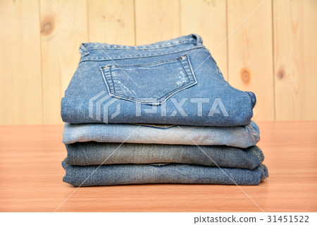 Blue jeans folded stack on wooden table on wooden Blue jeans folded stack on wooden table on wooden 31451522