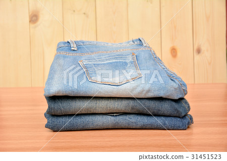 Blue jeans folded stack on wooden table on wooden Blue jeans folded stack on wooden table on wooden 31451523