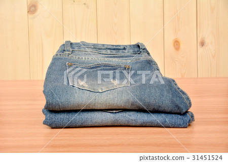 Blue jeans folded stack on wooden table on wooden 31451524