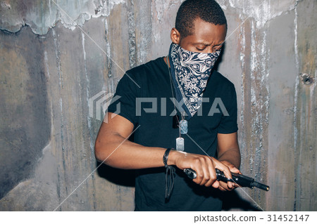 Black gang member checks his weapon 31452147