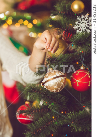 Toned image of young woman putting golden bauble 31452238