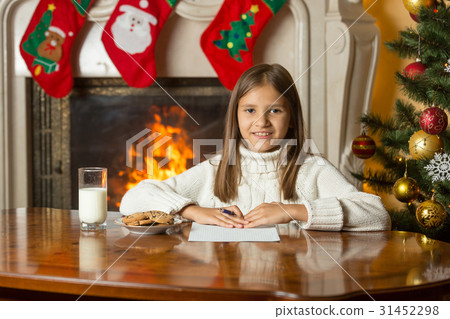 girl by fireplace writing letter to Santa girl by fireplace writing letter to Santa 31452298