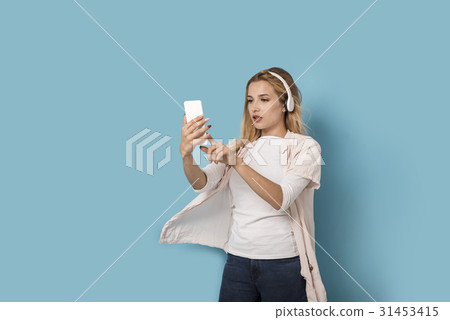 Young blonde is trying to pick the music 31453415