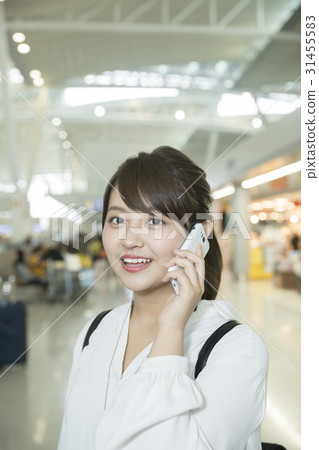 A young woman making a call in the airport A young woman making a call in the airport 31455583