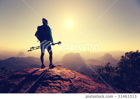 successful woman hiking on sunrise mountain top 31463313