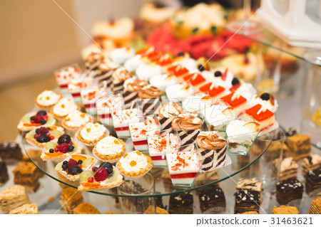 Delicious and tasty dessert table with cupcakes 31463621