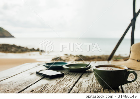 Cup of coffee and two saucers stand on a wooden 31466149