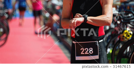Triathlete checks his time 31467615