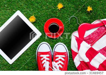 gumshoes, jacket on hanger, tablet and cup 31469457