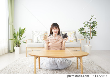 一位計算家庭的年輕女士 一位計算家庭的年輕女士 31472064