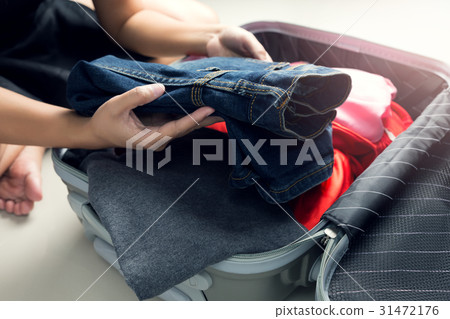 Women packing clothes into travel bag 31472176