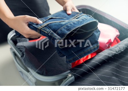Women packing clothes into travel bag 31472177