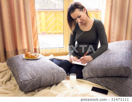 Attractive young woman writing on a notebook 31473111