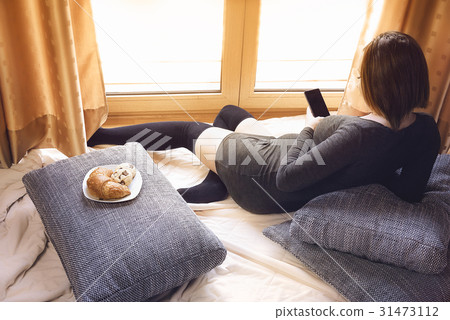 Pregnant redhead woman using a smartphone 31473112