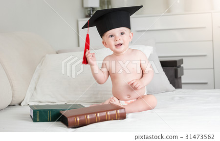 Funny baby in diapers wearing black graduation cap 31473562