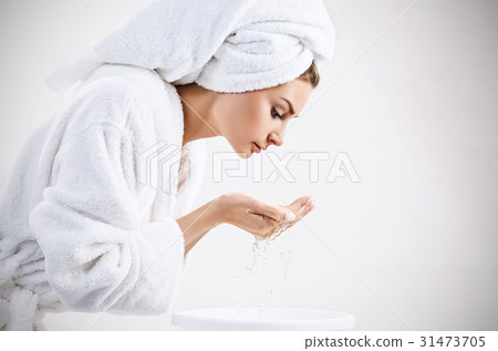 Young woman washing face with clean water. Young woman washing face with clean water. 31473705