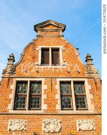 Ancient brick house gable with ornamental windows 31473828
