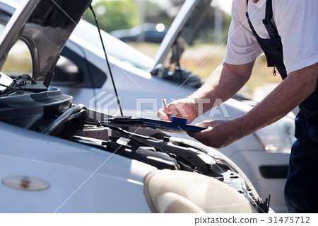 Auto mechanic checking car engine Auto mechanic checking car engine 31475712