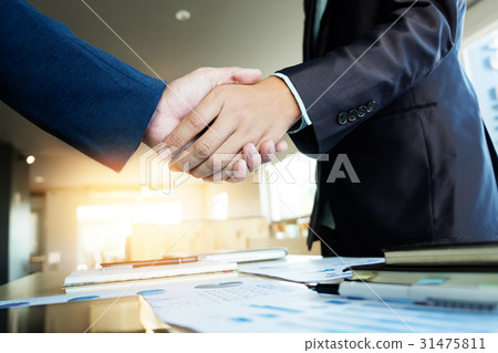 Two businessmen shaking hands during a meeting, s Two businessmen shaking hands during a meeting, s 31475811