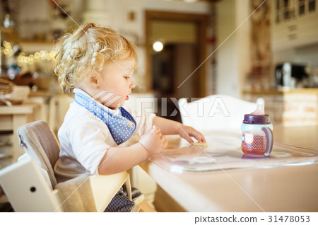 Cute little boy sitting at the table, eating and Cute little boy sitting at the table, eating and 31478053