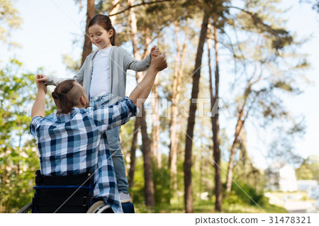 Brave girl standing on the knees of her father Brave girl standing on the knees of her father 31478321