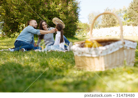 Positive delighted mother putting bonnet on head Positive delighted mother putting bonnet on head 31478480