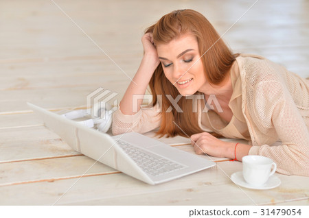 young woman lying on floor with laptop young woman lying on floor with laptop 31479054