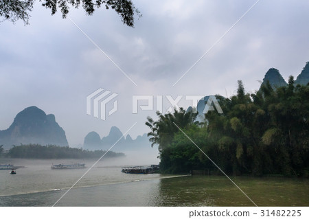 passenger boads in mist over river near Xingping 31482225