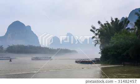 passenger ships in mist over river near Xingping 31482457