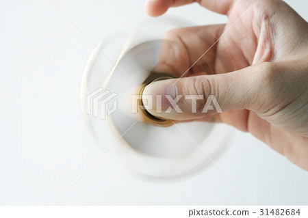 Isolated hand spinning golden metal fidget spinner Isolated hand spinning golden metal fidget spinner 31482684