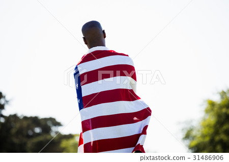 Athlete with american flag wrapped around his body Athlete with american flag wrapped around his body 31486906