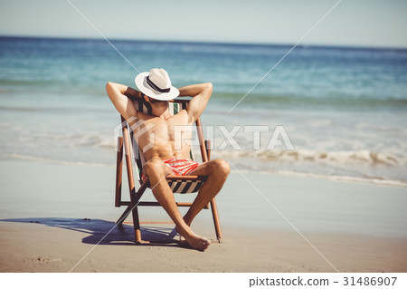 Man relaxing on armchair Man relaxing on armchair 31486907
