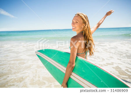 Woman posing with surfboard on beach 31486909