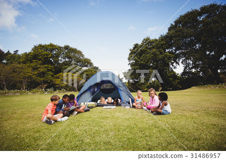 Smiling kids lying and reading in the tent together 31486957
