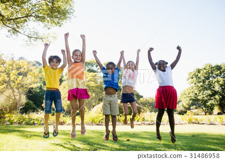 Happy kids jumping together during a sunny day Happy kids jumping together during a sunny day 31486958