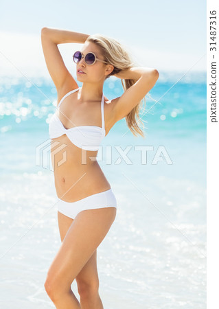 Woman wearing bikini posing with sunglasses Woman wearing bikini posing with sunglasses 31487316