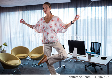 Businesswoman doing yoga on a table Businesswoman doing yoga on a table 31487326