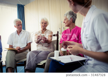 Seniors talking with nurse about medication Seniors talking with nurse about medication 31487328