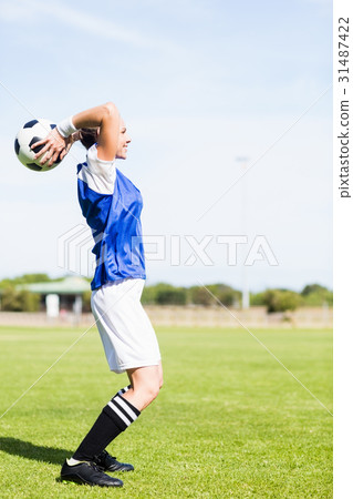 Female football player about to throw a football 31487422
