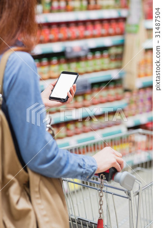 Customer in a store with a smartphone Customer in a store with a smartphone 31487504