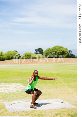 Male athlete preparing to throw shot put ball Male athlete preparing to throw shot put ball 31487678
