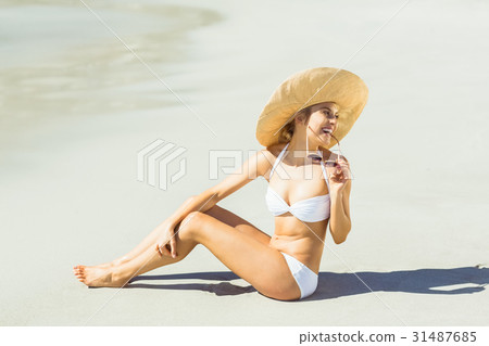Young woman in bikini sitting on beach 31487685