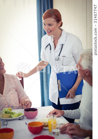 Pensioners at lunch with nurse 31487747
