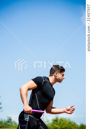 Relay athlete running with baton 31487937