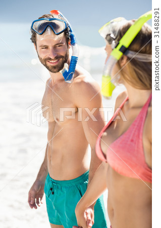 Couple holding hands standing on beach Couple holding hands standing on beach 31488291