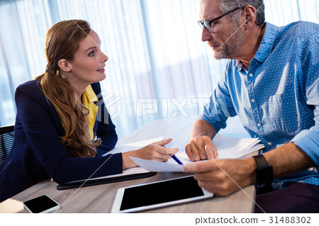Two businessmen reading a document and interacting 31488302