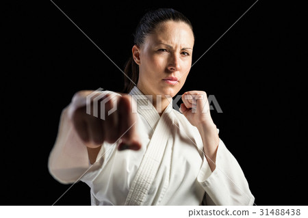 Female fighter performing karate stance Female fighter performing karate stance 31488438