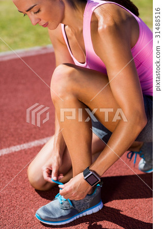 Female athlete tying her running shoes 31488516