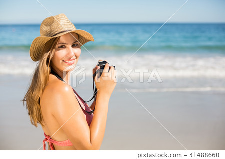Attractive woman in bikini taking photographs Attractive woman in bikini taking photographs 31488660
